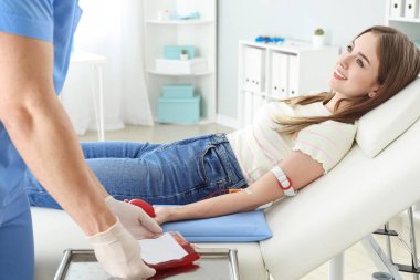 Woman donating blood in hospital clipart