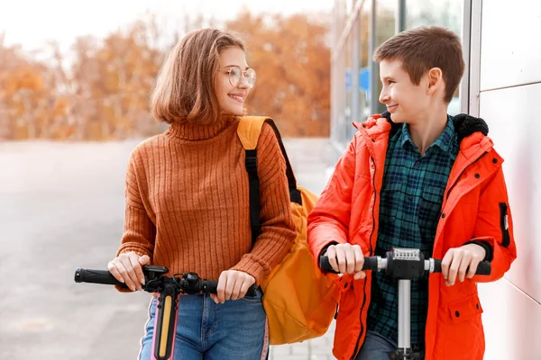 Adolescentes ativos montando scooters pontapé ao ar livre — Fotografia de Stock