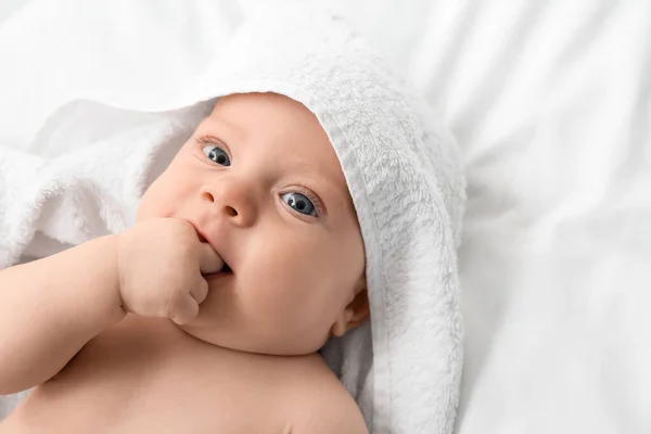 Portrait of cute little baby with towel lying on bed — Stock Photo, Image