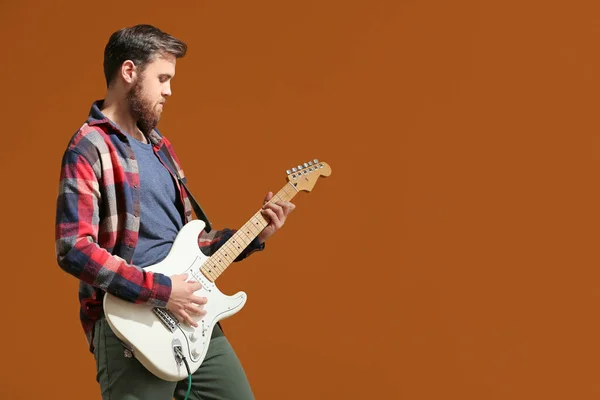 Young man playing guitar on color background — Stock Photo, Image