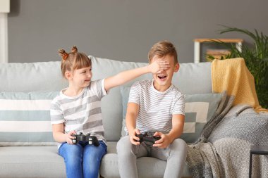Little children playing video games at home