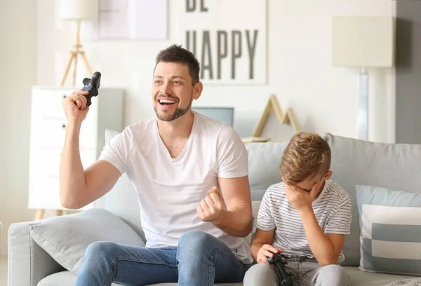 Pai e seu filhinho jogando videogames em casa — Fotografia de Stock