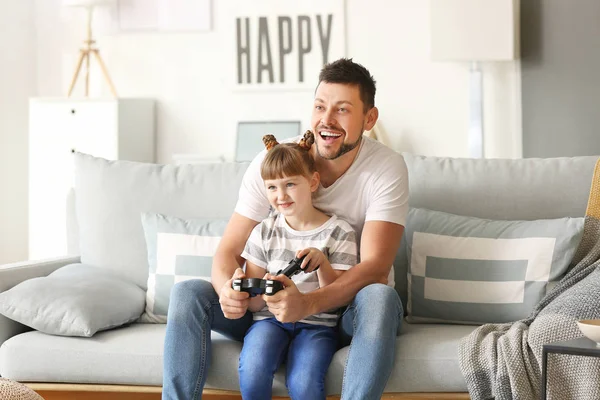 Ο πατέρας και η κόρη του παίζουν βιντεοπαιχνίδια στο σπίτι. — Φωτογραφία Αρχείου