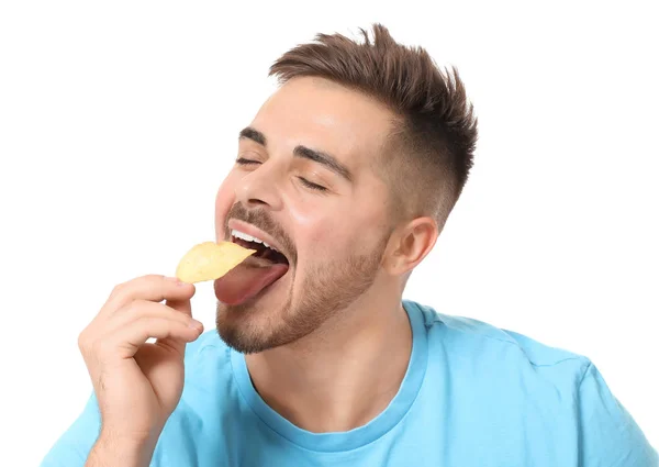 Guapo joven comiendo sabrosas papas fritas sobre fondo blanco —  Fotos de Stock