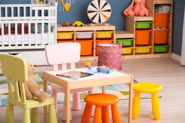 Interior of modern baby room with table and chairs
