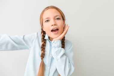 Tatlı küçük kız arka planda selfie çekiyor.