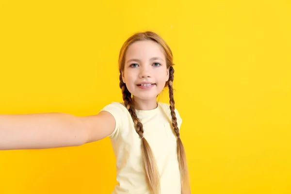 Carino bambina prendendo selfie su sfondo di colore — Foto Stock