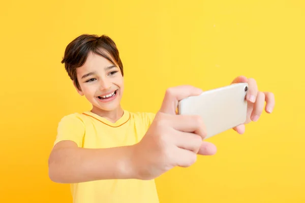 Schattig jongetje het nemen van selfie op kleur achtergrond — Stockfoto