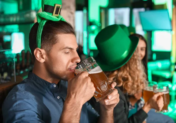 Jonge man met bier viert St. Patrick 's Day in pub — Stockfoto