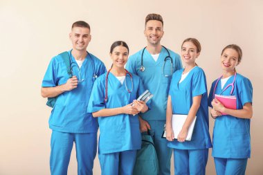 Group of medical students on light background