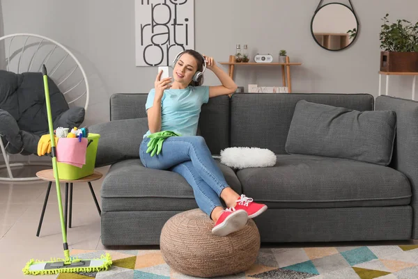 Молодая домохозяйка делает селфи вместо того, чтобы убирать квартиру — стоковое фото