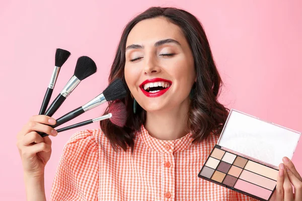 Hermosa joven aplicación de maquillaje en el fondo de color —  Fotos de Stock
