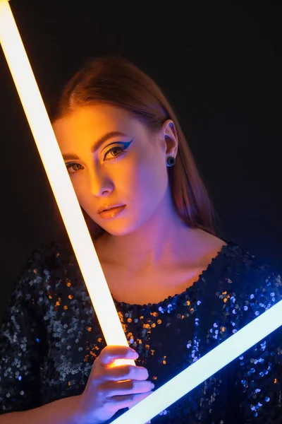 Tonat porträtt av vacker kvinna med neonlampor på mörk bakgrund — Stockfoto