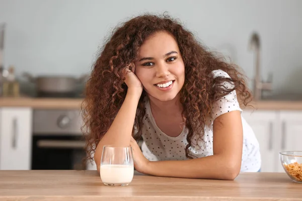 Young African-American woman with milk in kitchen — Stock Photo, Image