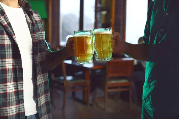 Jóvenes amigos con cerveza celebrando el Día de San Patricio en el pub, primer plano —  Fotos de Stock