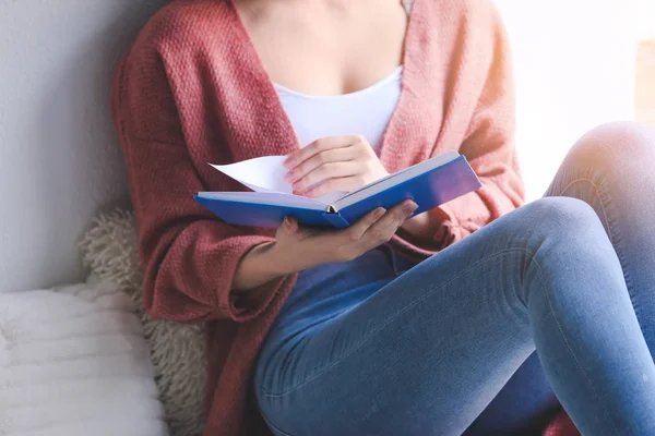 Młoda kobieta czyta książkę w domu, zbliżenie — Zdjęcie stockowe