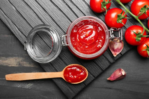 Glas mit leckerer Tomatensauce auf dem Tisch — Stockfoto