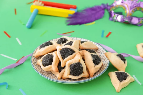 Plate with tasty hamantaschen and party decor for Purim holiday on color background — Stock Photo, Image