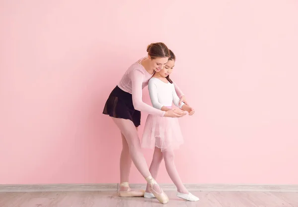 Pelatihan balerina kecil dengan pelatih melawan latar belakang warna — Stok Foto
