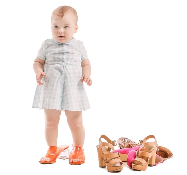 Cute baby ze stylowymi damskimi butami na białym tle — Zdjęcie stockowe