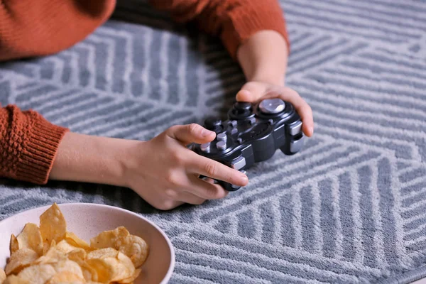 Little child playing video games at home in evening — Stok fotoğraf