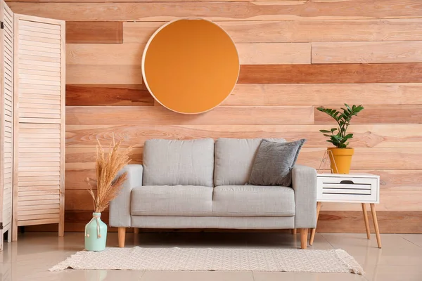 Interior of modern room with comfortable sofa near wooden wall — Stock Photo, Image