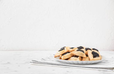 Beyaz arka planda Purim bayramı için lezzetli hamantaschen tabağı