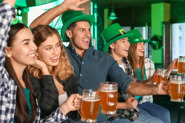 Young friends celebrating St. Patrick's Day in pub — Stock Photo, Image