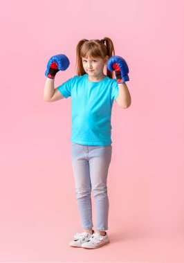 Little girl in boxing gloves on color background. Concept of feminism