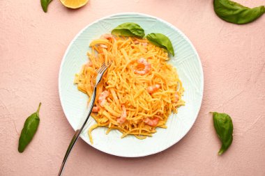 Plate with tasty pasta and shrimps on color background