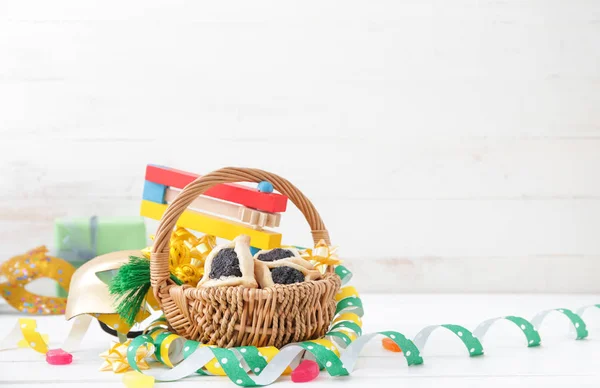 Basket with tasty hamantaschen and party decor for Purim holiday on white background — 스톡 사진