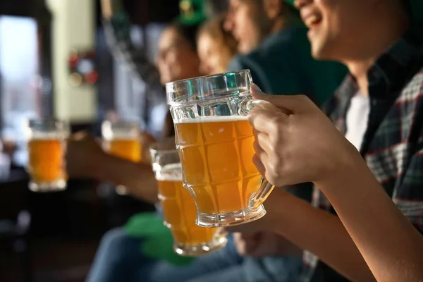 Jóvenes amigos con cerveza celebrando el Día de San Patricio en el pub, primer plano —  Fotos de Stock