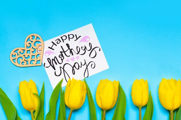 Vackra blommor med gratulationskort för Mors Dag på färg bakgrund — Stockfoto