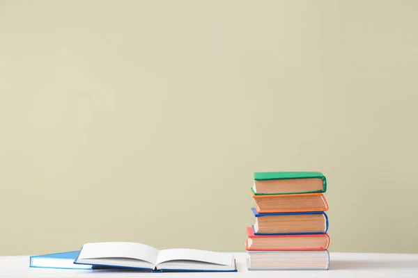 Many books on table against color background — Stock Photo, Image