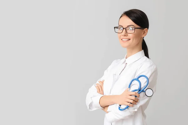 Female cardiologist on light background — Stock Photo, Image