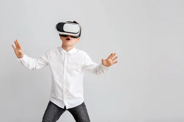Little boy with virtual reality glasses on grey background — Stock Photo, Image