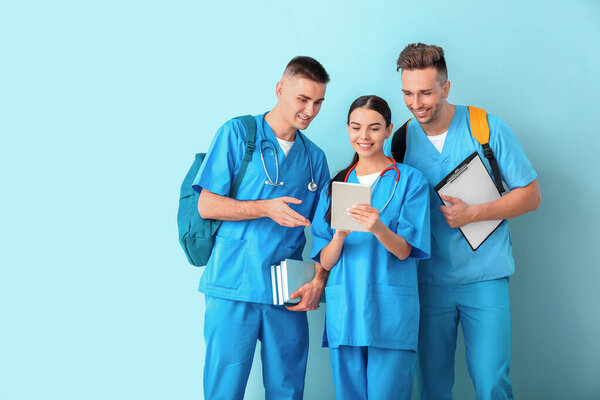 Group of medical students on color background