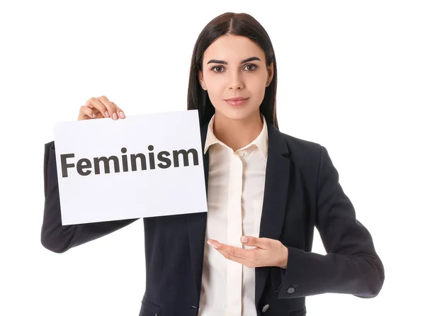 Young businesswoman holding paper with text FEMINISM on white background — ストック写真