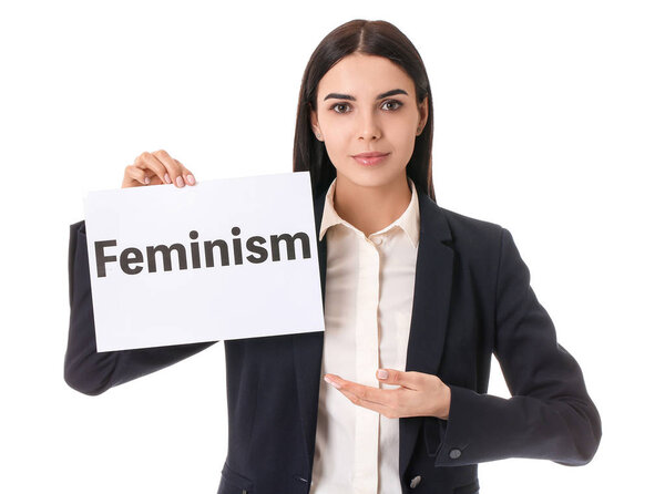 Young businesswoman holding paper with text FEMINISM on white background