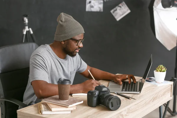 Fotógrafo afroamericano en mesa en estudio — Foto de Stock