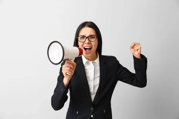 Screaming business woman with megaphone on light background. Concept of feminism — Stock Photo, Image