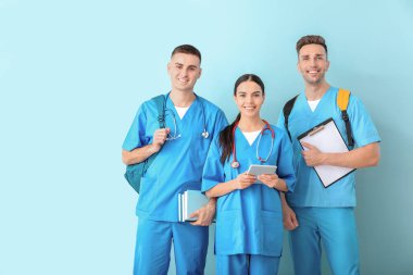 Group of medical students on color background