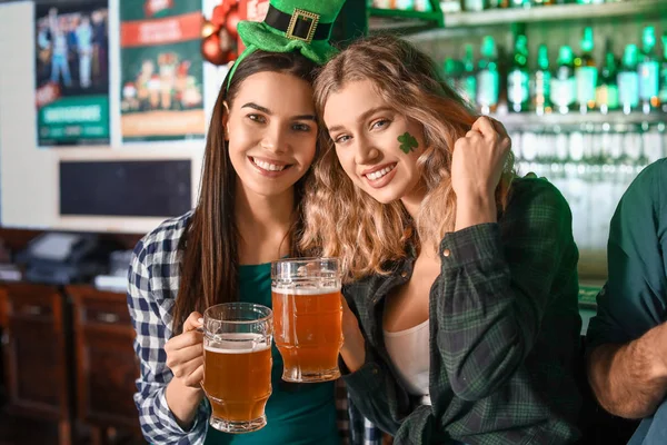 Young women with beer celebrating St. Patrick\'s Day in pub