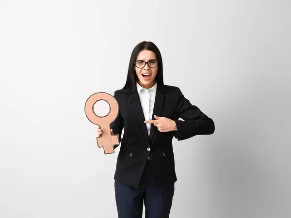 Young business lady holding symbol of woman on grey background — Stok fotoğraf