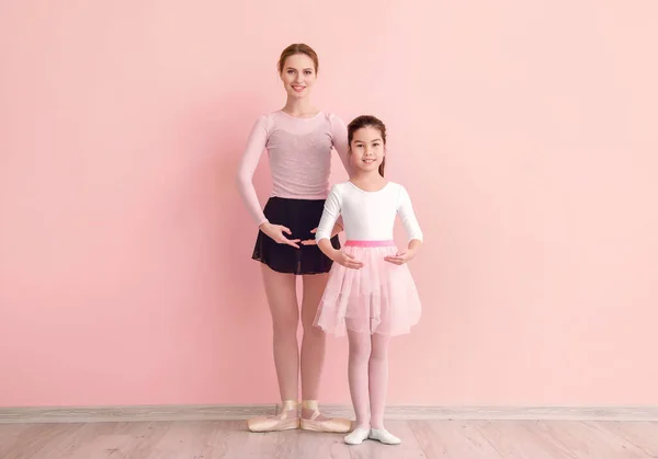 Pouco treinamento de bailarina com treinador contra fundo de cor — Fotografia de Stock