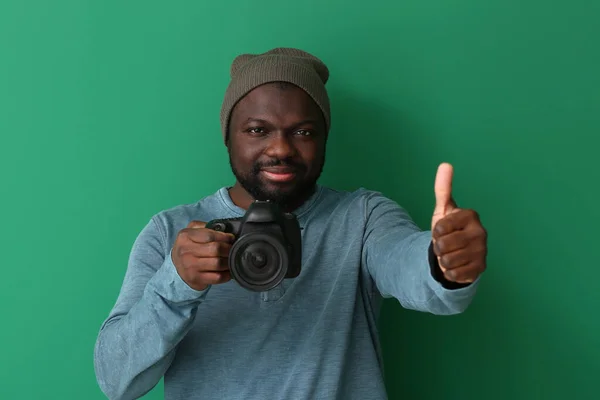 African-American photographer showing thumb-up on color background — Stock Photo, Image