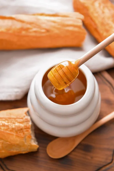 Süßer Honig und Brot auf dem Tisch — Stockfoto