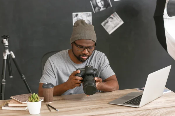Fotógrafo afroamericano en mesa en estudio — Foto de Stock