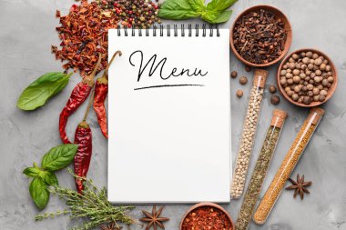 Notebook with word MENU and different spices on grunge background