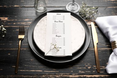 Beautiful table setting with menu on dark wooden background
